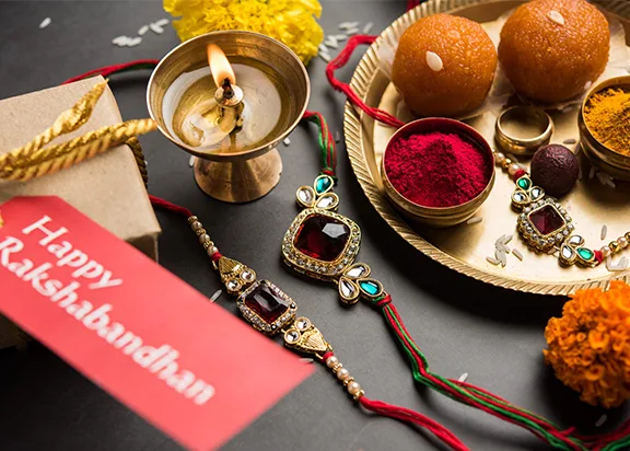 A complete Rakhi thali with diya, kumkum, rice, sweets and the rakhi